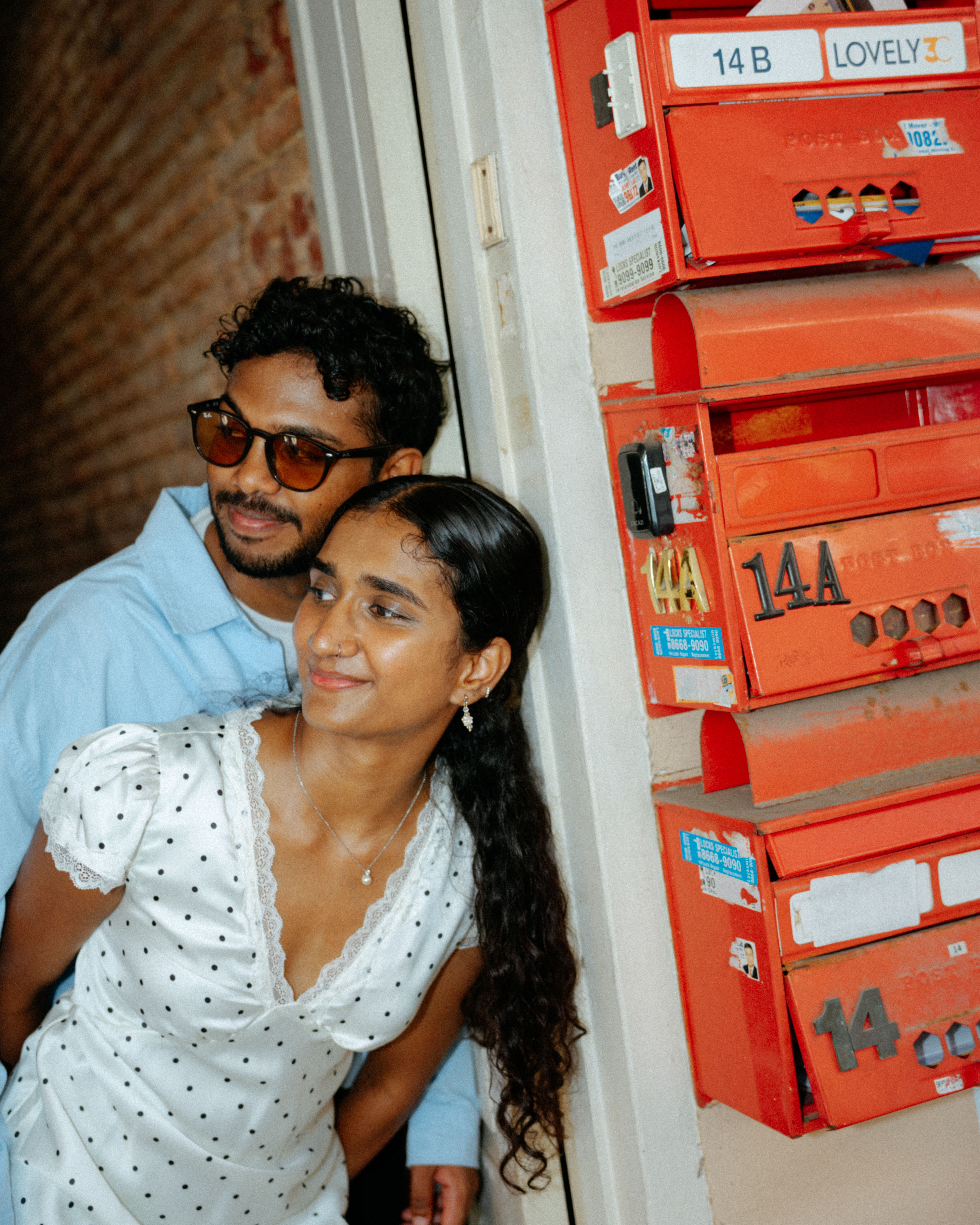 Janani and Dhanush posing near colorful architecture